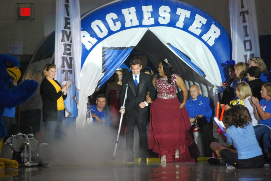 Juniors Grant Ellison and Kayla Dumars walking across the gym during the homecoming pep assembly.